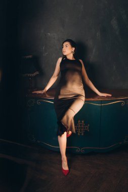 Siyah elbiseli güzel bir kızın fotoğraf stüdyosunda fotoğraf çekimi.