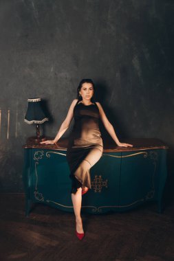 Siyah elbiseli güzel bir kızın fotoğraf stüdyosunda fotoğraf çekimi.