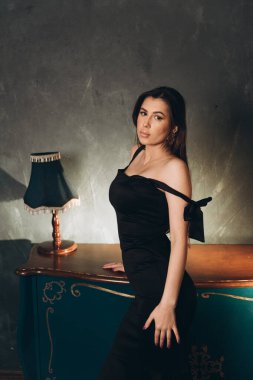 Siyah elbiseli güzel bir kızın fotoğraf stüdyosunda fotoğraf çekimi.