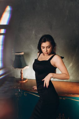 Siyah elbiseli güzel bir kızın fotoğraf stüdyosunda fotoğraf çekimi.