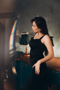 Siyah elbiseli güzel bir kızın fotoğraf stüdyosunda fotoğraf çekimi.