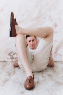 Şık bir adam, model, şık şortlu ve atölyede bir gömlek, yaz modası.