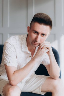 Şık bir adam, model, şık şortlu ve atölyede bir gömlek, yaz modası.