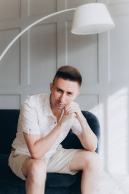 Şık bir adam, model, şık şortlu ve atölyede bir gömlek, yaz modası.