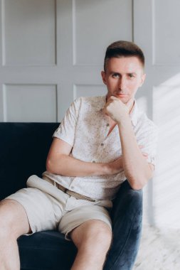 Şık bir adam, model, şık şortlu ve atölyede bir gömlek, yaz modası.