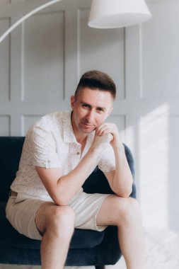 Şık bir adam, model, şık şortlu ve atölyede bir gömlek, yaz modası.