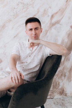 Şık bir adam, model, şık şortlu ve atölyede bir gömlek, yaz modası.