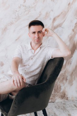 Şık bir adam, model, şık şortlu ve atölyede bir gömlek, yaz modası.