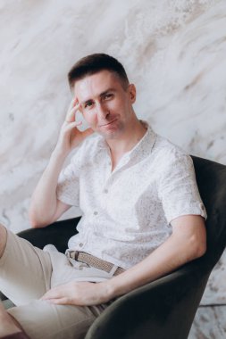 Şık bir adam, model, şık şortlu ve atölyede bir gömlek, yaz modası.