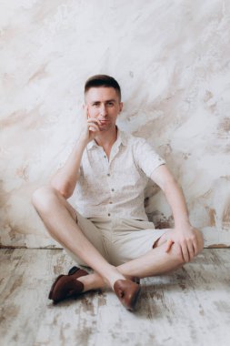 Şık bir adam, model, şık şortlu ve atölyede bir gömlek, yaz modası.