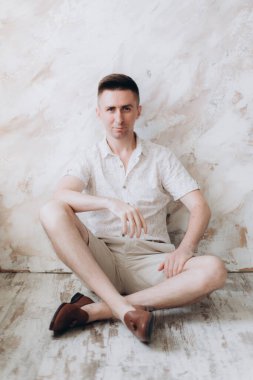 Şık bir adam, model, şık şortlu ve atölyede bir gömlek, yaz modası.