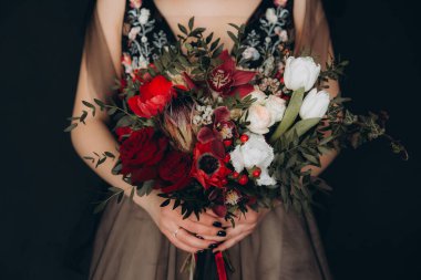 Siyah dekorlu şölen masası, mumlar, pasta ve çiçekler, marsal ve garnet, altın çatal bıçak takımı.