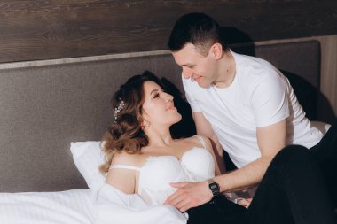 Gelin ve damadın güzel, duygusal ve neşeli buluşmaları beyaz giysiler içinde odada.