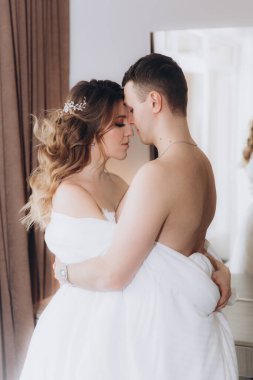 Gelin ve damadın güzel, duygusal ve neşeli buluşmaları beyaz giysiler içinde odada.