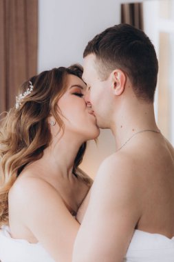 Gelin ve damadın güzel, duygusal ve neşeli buluşmaları beyaz giysiler içinde odada.