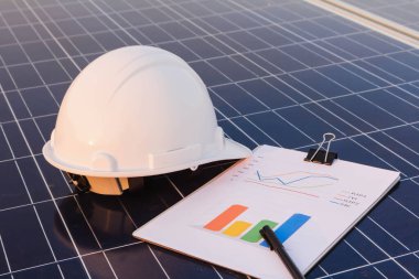 Mühendisler alternatif enerji olan ve sürdürülebilir kaynaklar kavramı olan güneş panellerinden enerji üretiminin performans grafiğini inceliyorlar..