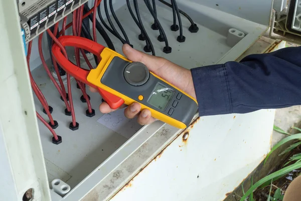 Workers use Clamp meter to measure the current of electrical wires produced from solar energy for confirm to systems working normal.