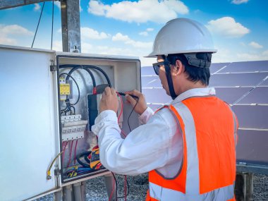 Mühendisler güneş panelinin performansını kontrol etmek için sistemlerin normal çalıştığını doğrulamak için Multimetre kullandılar. Güneş pili santrali için profesyonel mühendis kavramları.
