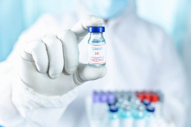 Bilimsel laboratuvardan bir doktorun elindeki aşı şişesini kapat. COVID-19 salgınının tedavisinde ve korunmasında kullanılan bir ilaç konsepti..