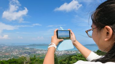 Genç kadın cep telefonları ile fotoğraf alarak