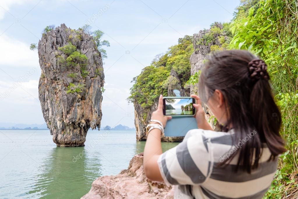 Female traveler shooting natural view by mobile phone