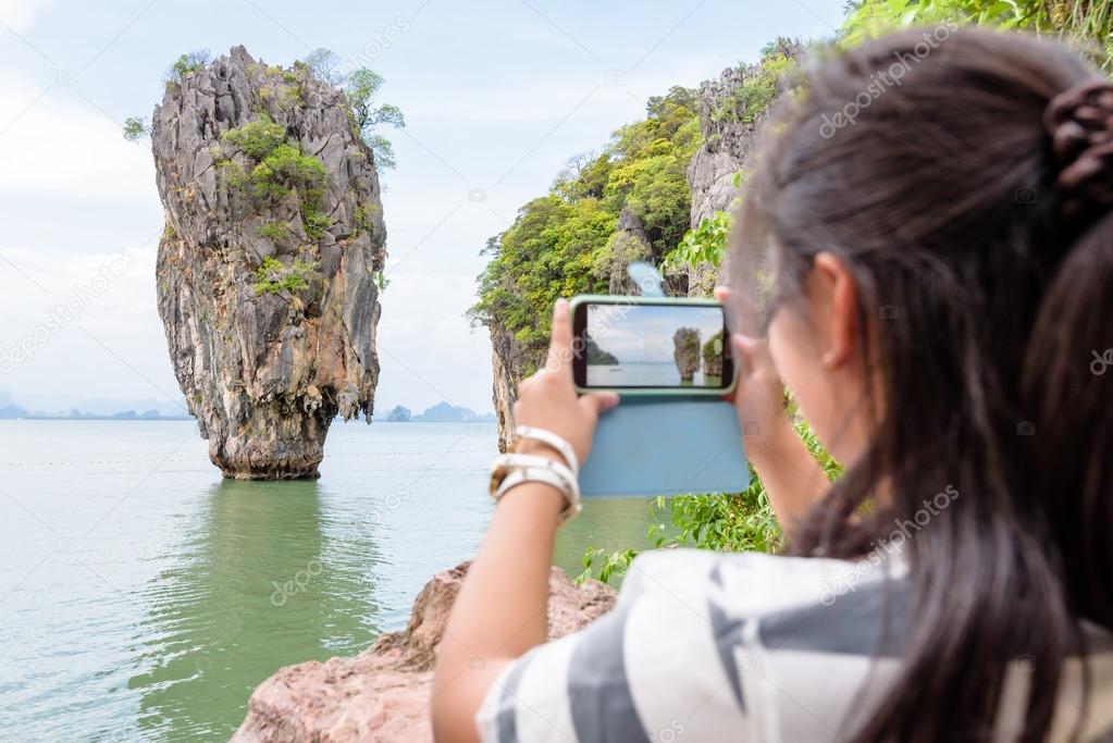 Female traveler shooting natural view by mobile phone