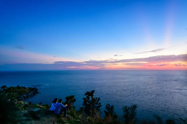 Pár a turisty čekání na západ slunce nad mořem — Stock fotografie