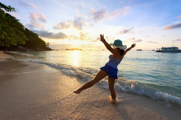 日出在沙滩上快乐的女孩 免版税图库照片