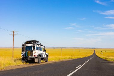 Karoo, Güney Afrika - 17 Mart 2019: Eski Land Rover Defender Güney Afrika kırsalında ulusal bir otoyolun yanında park etti