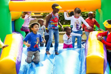 Johannesburg, Güney Afrika - 22 Eylül 2012: Çeşitli çocuklar açık hava lunaparkında atlayan bir kalede eğleniyorlar