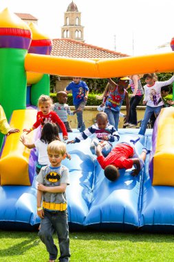 Johannesburg, Güney Afrika - 22 Eylül 2012: Çeşitli çocuklar açık hava lunaparkında atlayan bir kalede eğleniyorlar