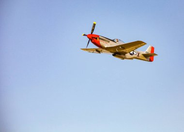 Johannesburg, South Africa - May 22, 2011: World War 2 US Air-Force Mustang fighter plane flying through the air clipart