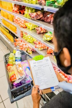 Cape Town, Güney Afrika - 10 Aralık 2020: Personel üyesi market ürünlerini yerel Pick n Pay süpermarketinde ekspres ev teslimatı için raftan topladı 