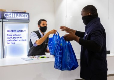 Cape Town, Güney Afrika - 10 Aralık 2020: Express Servisi teslimatçısı yerel Pick n Pay marketindeki personelden sipariş topluyor