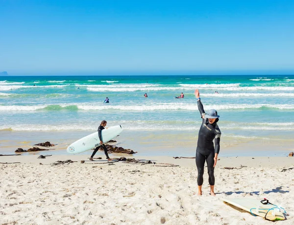 Cape Town, Güney Afrika - 23 Mart 2021: Muizenberg plajında sörfçüler ve yüzücüler