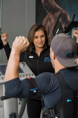 Johannesburg, Güney Afrika - 27 Temmuz 2017: Bir spor salonunda selülitleri azaltmak ve kalorileri yakmak için elektro-kas makineleriyle çalışan kişisel antrenör