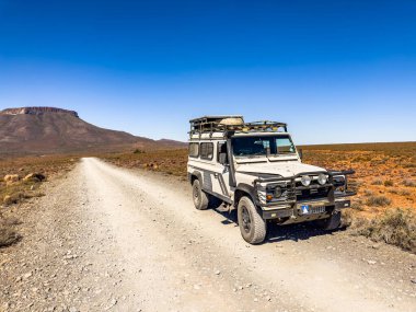 Karoo, Güney Afrika - 27 Ekim 2025: Eski Land Rover Defender kurak bir bölgeye park etti