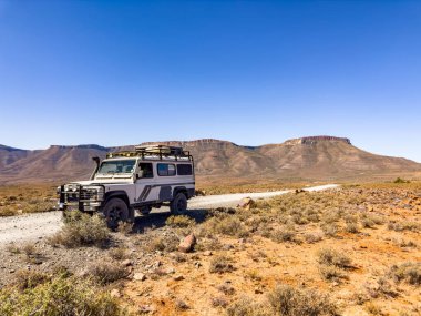 Karoo, Güney Afrika - 27 Ekim 2025: Eski Land Rover Defender kurak bir bölgeye park etti