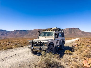 Karoo, Güney Afrika - 27 Ekim 2025: Eski Land Rover Defender kurak bir bölgeye park etti
