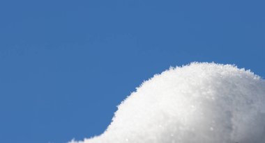 Kışın yağan kar mavi gökyüzüne karşı. 