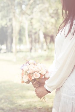 Stok fotoğraf A kadının elini yumuşak odak vintage tarzı bir buket çiçek tutuyor