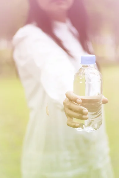 Stock Fotó-ázsiai nő gazdaság természetes vizet a műanyag palack lágy fókusz vintage stílusú — Stock Fotó