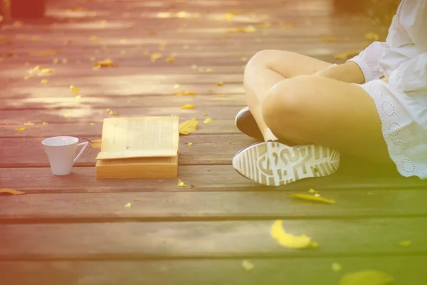 Sevimli genç kadın parkta üzerinde oturan ve kitap yumuşak f okuma — Stok fotoğraf