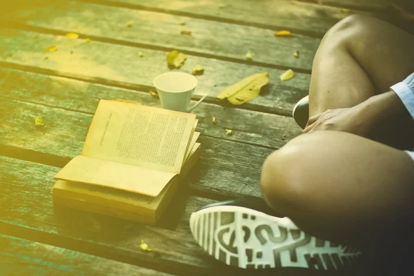 Linda joven sentada en el parque y leyendo el libro suave f — Foto de Stock