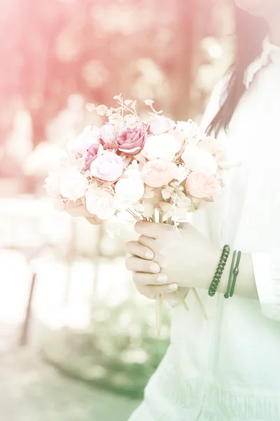 Stock Photo A womans hand is holding a bouquet of flowers soft focus vintage style — Stock Photo, Image