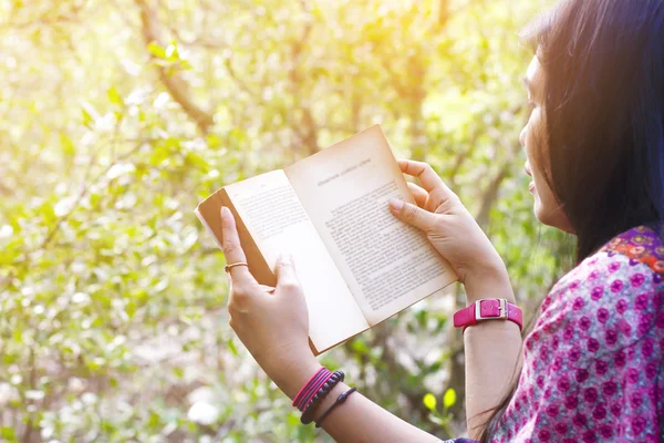 Молодая женщина, читающая книгу в лесу — стоковое фото