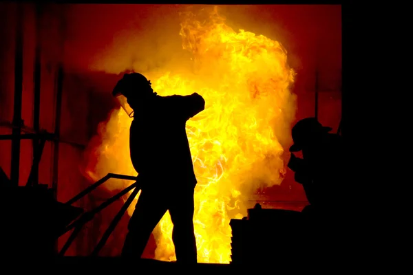 Harte Arbeit in einer Gießerei, wo Eisen geschmolzen wird — Stockfoto