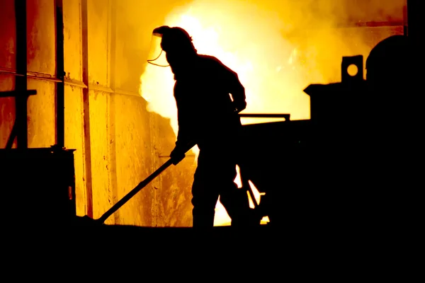 Lavorare sodo in una fonderia, fondere ferro — Foto Stock