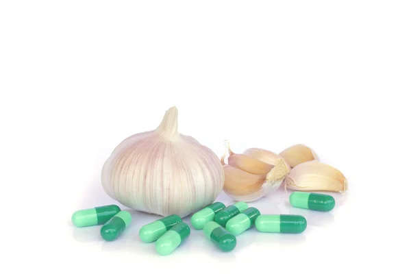 Pílulas de ervas e alho em um fundo de cor clara — Fotografia de Stock