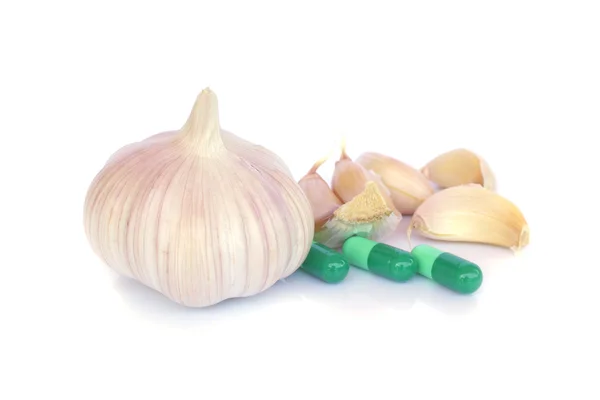 Pillole a base di erbe e aglio su uno sfondo di colore chiaro — Foto Stock